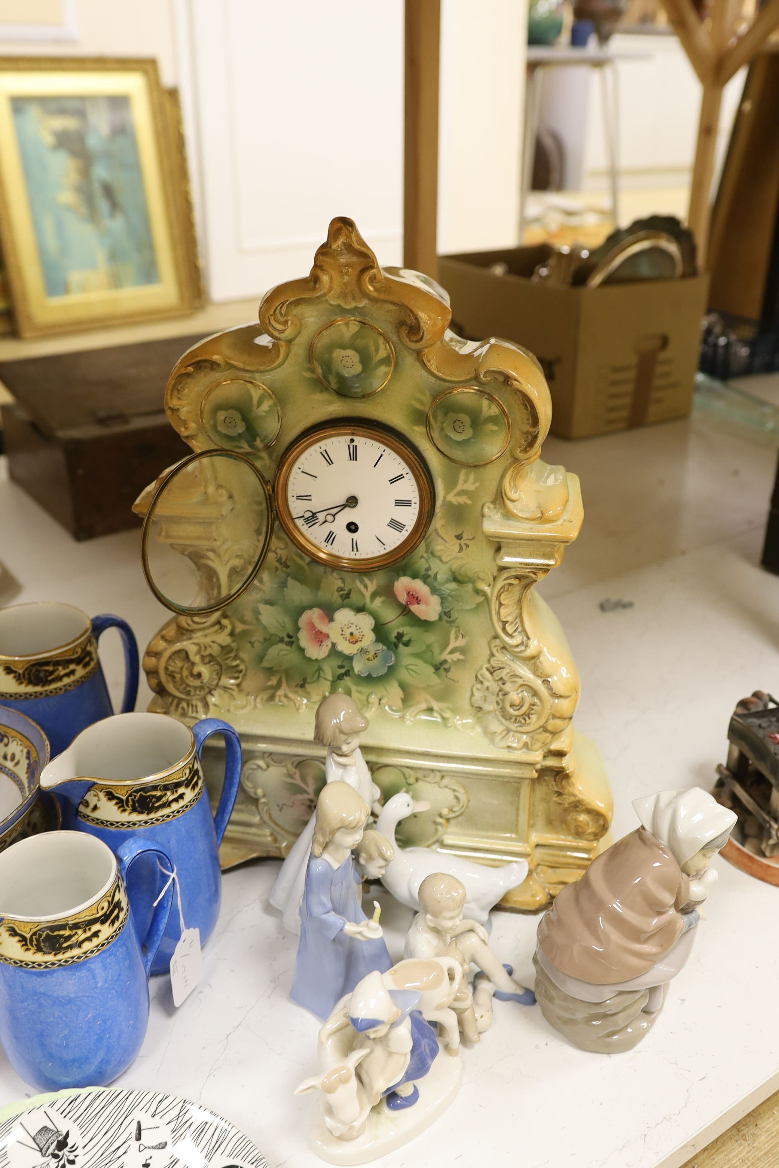 Six mixed Nao and other similar figures, a Homemaker plate, a Carltonware plate, four graduated jugs, and two pedestal bowls, a pair of mottoware candlesticks and a French china mantel clock